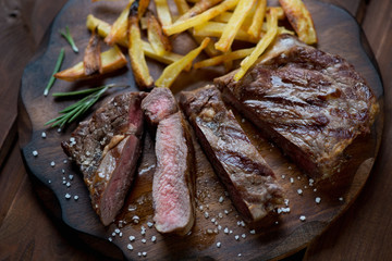 Close-up of sliced medium grilled ribeye steak with potato