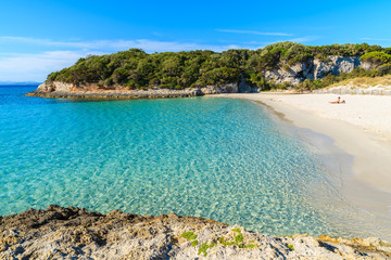 Unidentified young couple relaxing on beautiful Petit Sperone beach, Corsica island, France