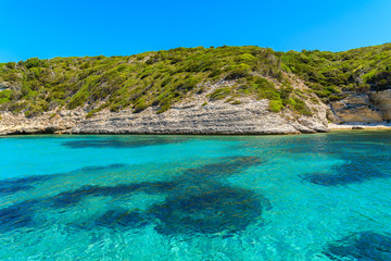 Fototapeta na wymiar Crystal clear sea water in secluded bay near Bonifacio town, Corsica island, France
