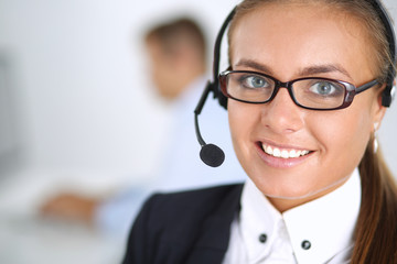 Happy female wearing headset and sitting on the desk