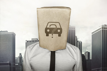 Buy a car concept on brown paper bag which businessman has on head - obrazy, fototapety, plakaty