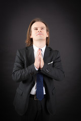 Handsome man doing different expressions in different sets of clothes: prayer