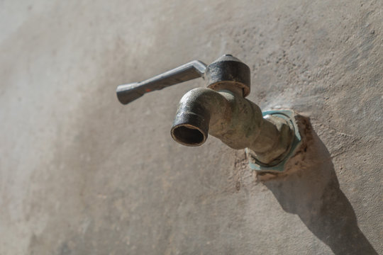 old faucet on concrete wall, save the water concept