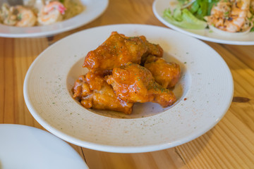 Crispy chicken wings on white dish