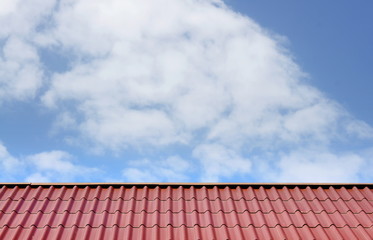 Red roof on clouds sky background