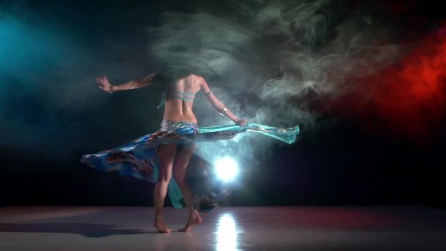 Talanted belly dance movements of young and attractive girl in