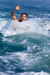 Mann wird im Wasser vom Boot gezogen