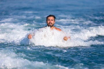 Mann wird im Wasser vom Boot gezogen