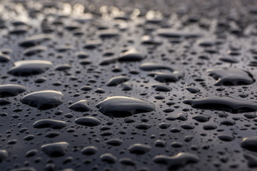 Wassertropfen auf schwarzem Lack