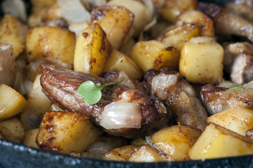 Potatoes fried on pan with meat
