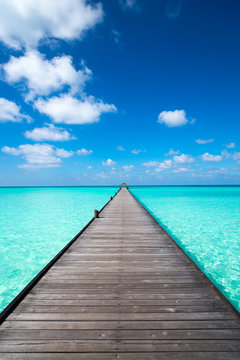 Fototapeta Wooden pier with blue sea and sky background