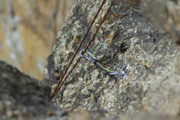 Climbing. A safety bolt threaded a rope with a carbine. Granite