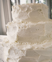 Blank white frosted wedding cake with three tiers.