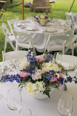 Flower arrangements on tables with glasses.