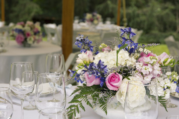 Flower arrangements on tables with glasses.
