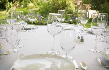 Glasses, plates, silverware on a table for a party.