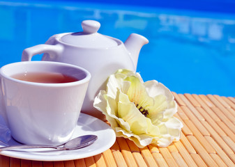 Cup of tea on a saucer and teapot
