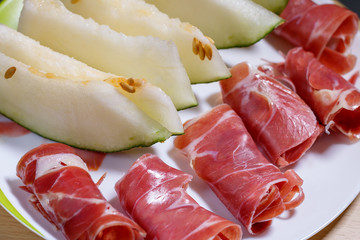 Closeup of slices of cured pork ham jamon with melon