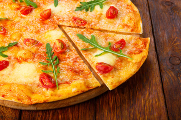 Delicious pizza with cherry tomatoes, mozzarella and fresh arugu