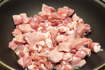 meat cut into pieces fried in a pan
