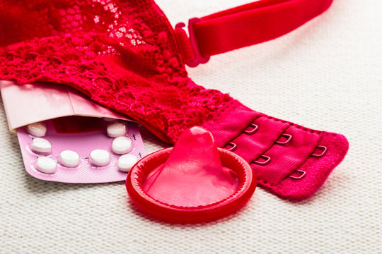 Pills and condom with lace lingerie.