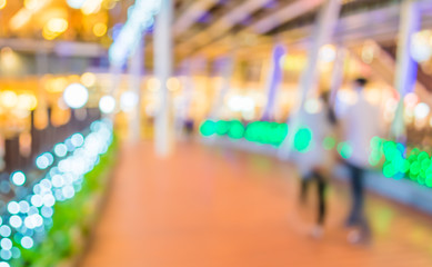 blur image of people walking at corridor on night time with boke