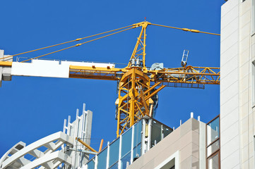 Crane and building construction site against blue sky
