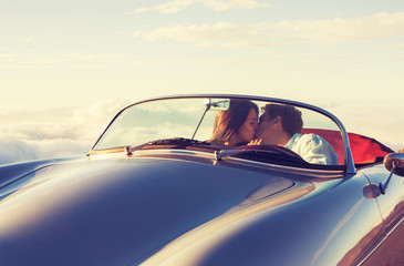 Fototapeta na wymiar Couple Watching the Sunset in Classic Vintage Car