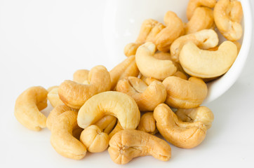 Raw cashews close-up in white bowl.