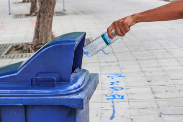 Obraz na płótnie Canvas Hand throwing Bottle in the Litter Bin.