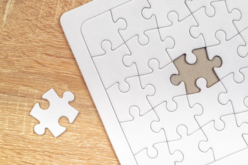 Piece missing from jigsaw puzzle on wooden table