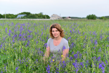 Adult woman in meadow with wild flowers
