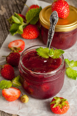 strawberry jam in a glass jar and fresh strawberries, decorated