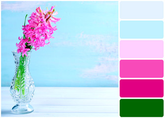 Beautiful hyacinth flower in vase on wooden table and palette of colors