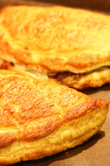Cornish pasties.
Freshly baked Cornish pasties on a baking tray.