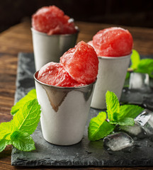 Frozen watermelon balls on a black stone plaque