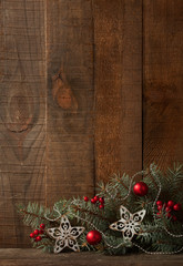 Fir branch with Christmas decoration on  old wooden plank.