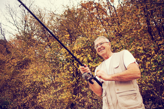 Happy senior man fishing