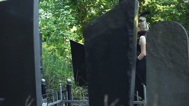 Woman walks through the cemetery horror among the graves. Gothick style.