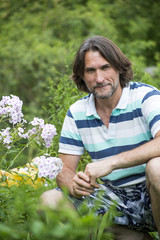 A man near the flowerbeds in the garden