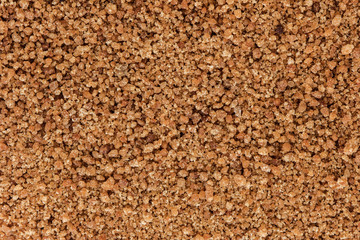 Background of organic brown coconut palm sugar, viewed from above.
