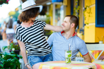 happy couple drinking lemonade or mojito in an outside cafe