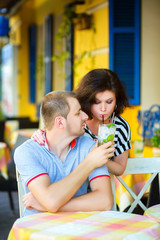 Obraz premium happy couple drinking lemonade or mojito in an outside cafe