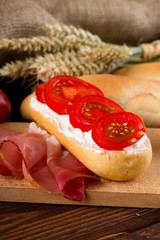 Piece of baguette with fresh gervais cream cheese and tomatoes