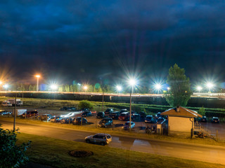 car parking at night with street lights and dark clouds