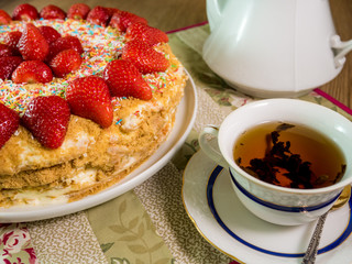 honey cake with strawberry on top and tea