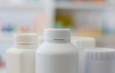 many medicine bottle with blur shelves of drug in the pharmacy d