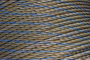 Steel rope coil, iron cable, wire of grey, blue and gold colors, hawser abstract texture, industrial background 