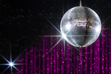 Disco ball with stars in nightclub with striped pink and black walls lit by spotlight 