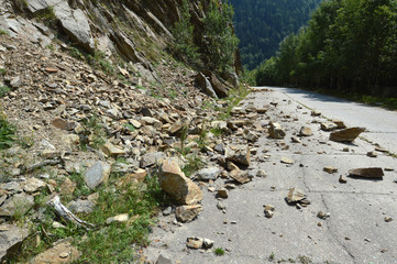 Rockfall in Carpathians where the road is covered with stones

